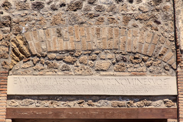 Tafel aus Stein in einer antiken Mauer mit römischer Schrift