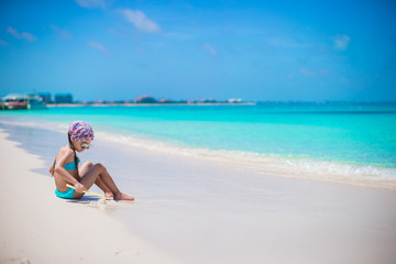Fototapeta na wymiar Little girl on seashore during summer vacation