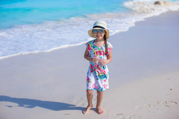 Adorable little girl at white beach during summer vacation