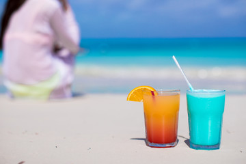 Close up tasty cocktails on beach background young woman