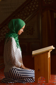 Young muslim woman reading Quran in turkish mosque