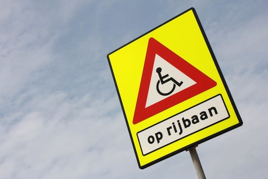 niederländisches Verkehrszeichen: Rollstuhlfahrer auf der Fahrbahn