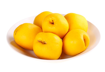 Bowl of flowering quince fruit isolated against white