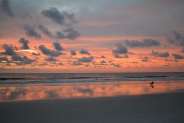 Obraz premium Man Sitting in Chair on Beach Watching Amazing Sunrise