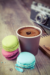 macaroons, espresso coffee cup, sketch book and retro camera on