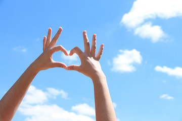 Young girl holding hands in heart shape framing