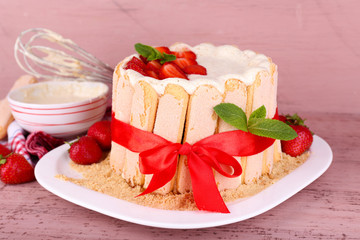 Tasty cake Charlotte with fresh strawberries on wooden table