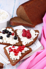 Bread with cottage cheese and berries on plate close-up