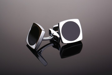 Pair of cuff links on dark grey background