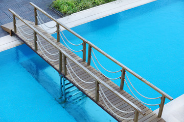 Fototapeta na wymiar Bridge across hotel swimming pool