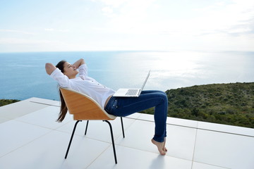 relaxed young woman at home working on laptop