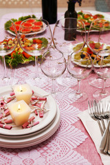 Buffet table with dishware and candles waiting for guests