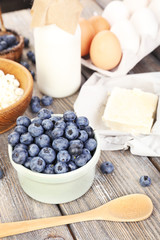 Fresh blueberries and milk products on wooden table