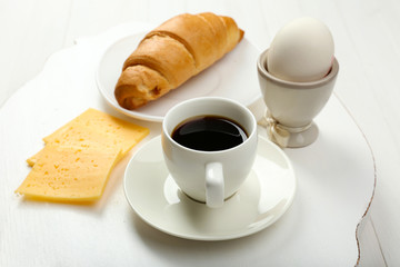 Delicious breakfast with coffee, fresh croissant, egg and