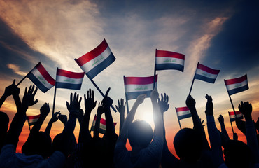 Silhouettes of People Waving the Flag of Iraq - obrazy, fototapety, plakaty