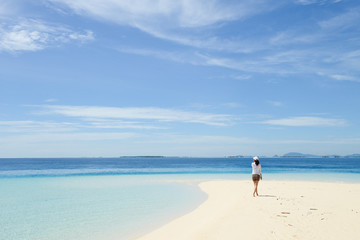 Fototapeta na wymiar beautiful young girl looking at horizon on tropical beach