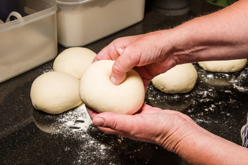 Baker forming bagels from dough