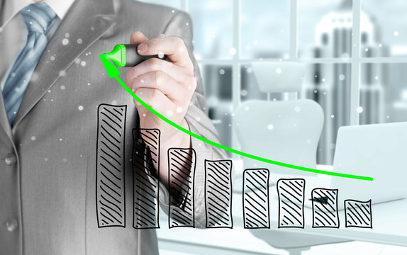 Business man drawing a growing graph