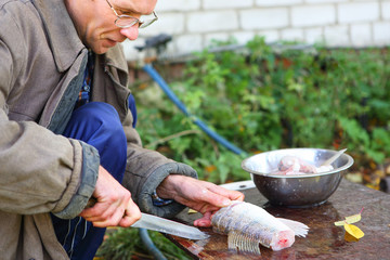 man cut up fish for cooking