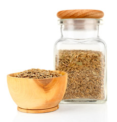 Square glass bottle and wooden round bowl with seasoning
