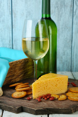 Wine, cheese and crackers on wooden table close-up