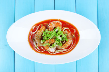 Fresh prawns with spaghetti and lettuce in tomato sauce in a