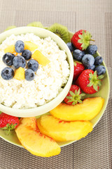 Cottage cheese with fruits and berries in bowl on table