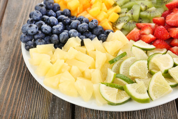 Sliced fruits on plate on wooden table