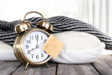 Alarm clock with sticker on bright background