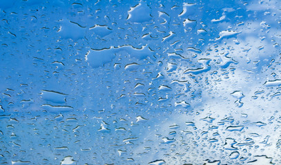 Water drops window glass blue sky