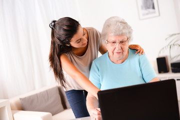 young woman helping old person for paperwork and telephone call
