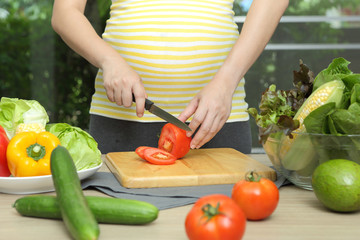 Pregnant woman is cooking - Powered by Adobe