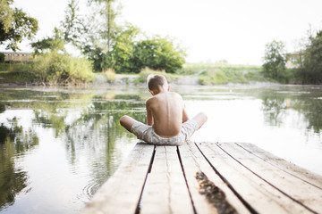 Boy sitting at the lake © bramgino