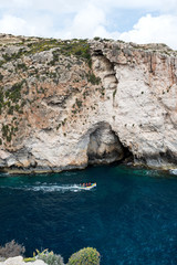 Fototapeta premium Caves and cliffs at the coast of Gozo Island tourists