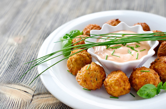 Falafels on a plate with dip sauce and herbs