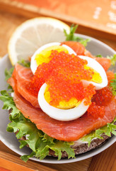 Sandwich with salted salmon, egg and red caviar