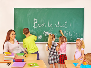 Children writing on blackboard.