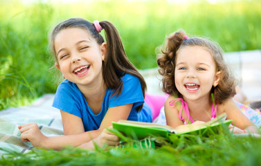 Two little girls are reading book