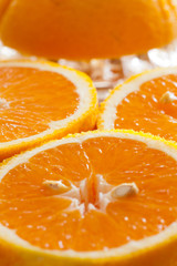 Plakat Saftige Orangen halbiert mit Zitruspresse im Hintergrund