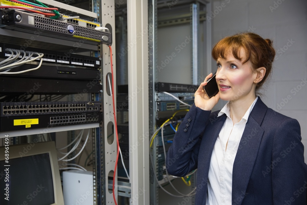 Aufkleber Pretty computer technician talking on phone beside open server