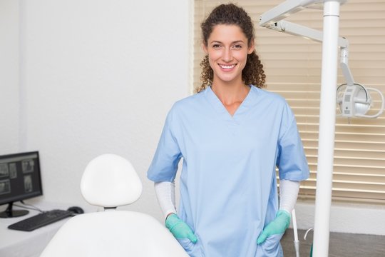 Dentist In Blue Scrubs Smiling At Camera