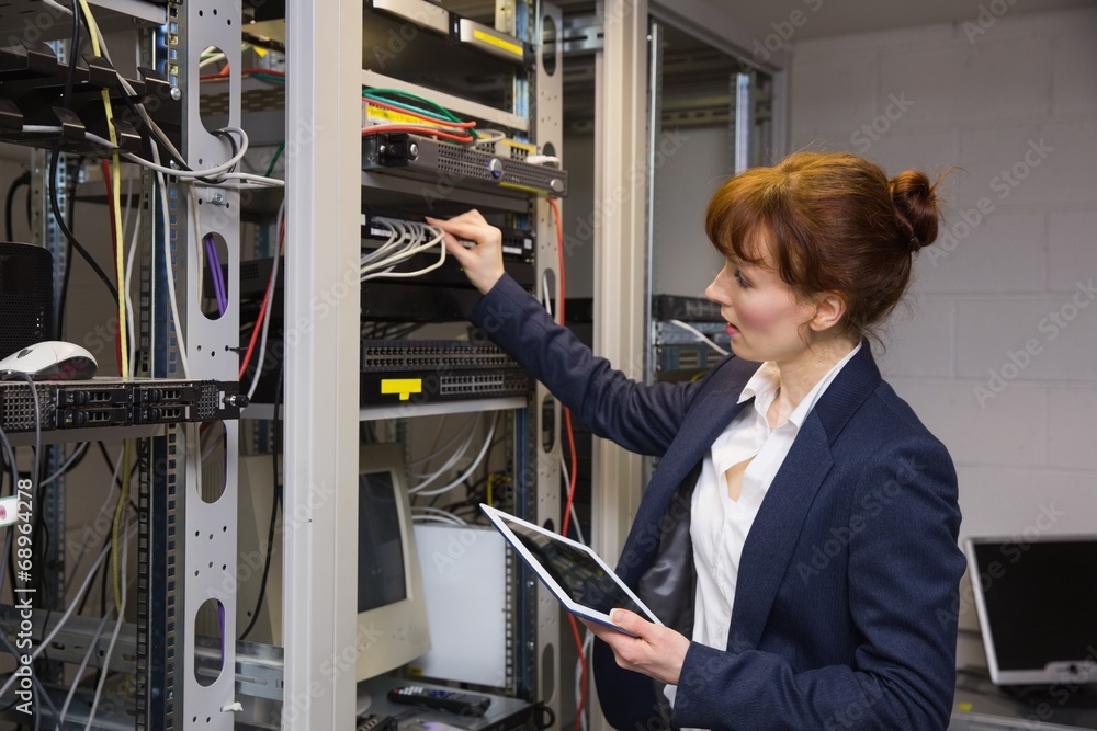 Aufkleber Pretty technician using tablet pc while fixing server