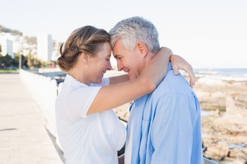 Happy casual couple hugging by the coast