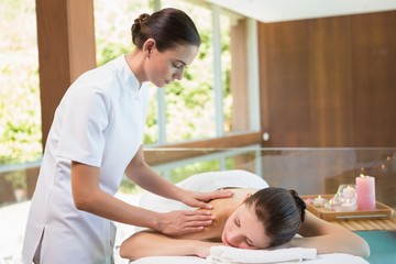 Attractive woman receiving back massage at spa center