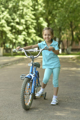 Fototapeta na wymiar Little girl with bicycle in summer