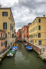 venetian channel with gondolas under clouds