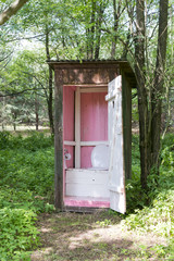 Old wooden outdoors toilet in summer.