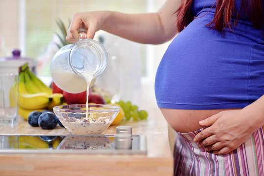 pregnant woman pouring milk