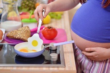 pregnant woman prepares a meal