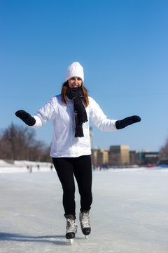 Healthy young woman ice skating during winter